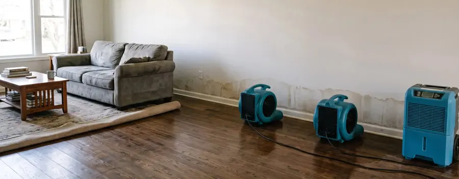 Air movers drying a living room after a water loss in Bedford, TX