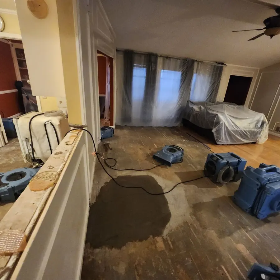 Air movers and a dehumidifier drying two rooms in Bedford, TX